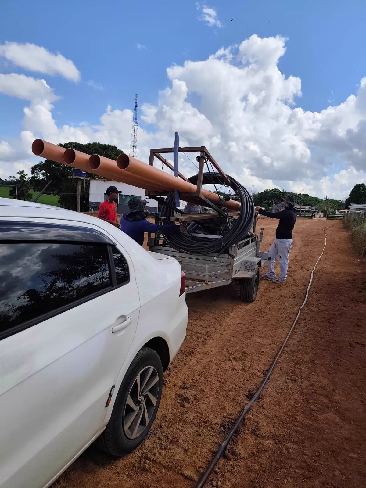 Equipe da DK Artesiano transportando tubos e equipamento de perfuração