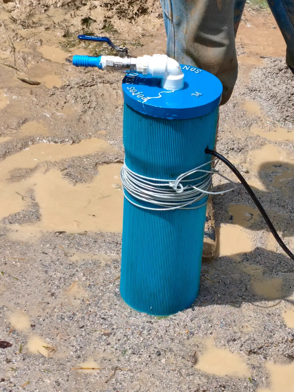 Pré-filtro azul do poço em meio à lama da perfuração